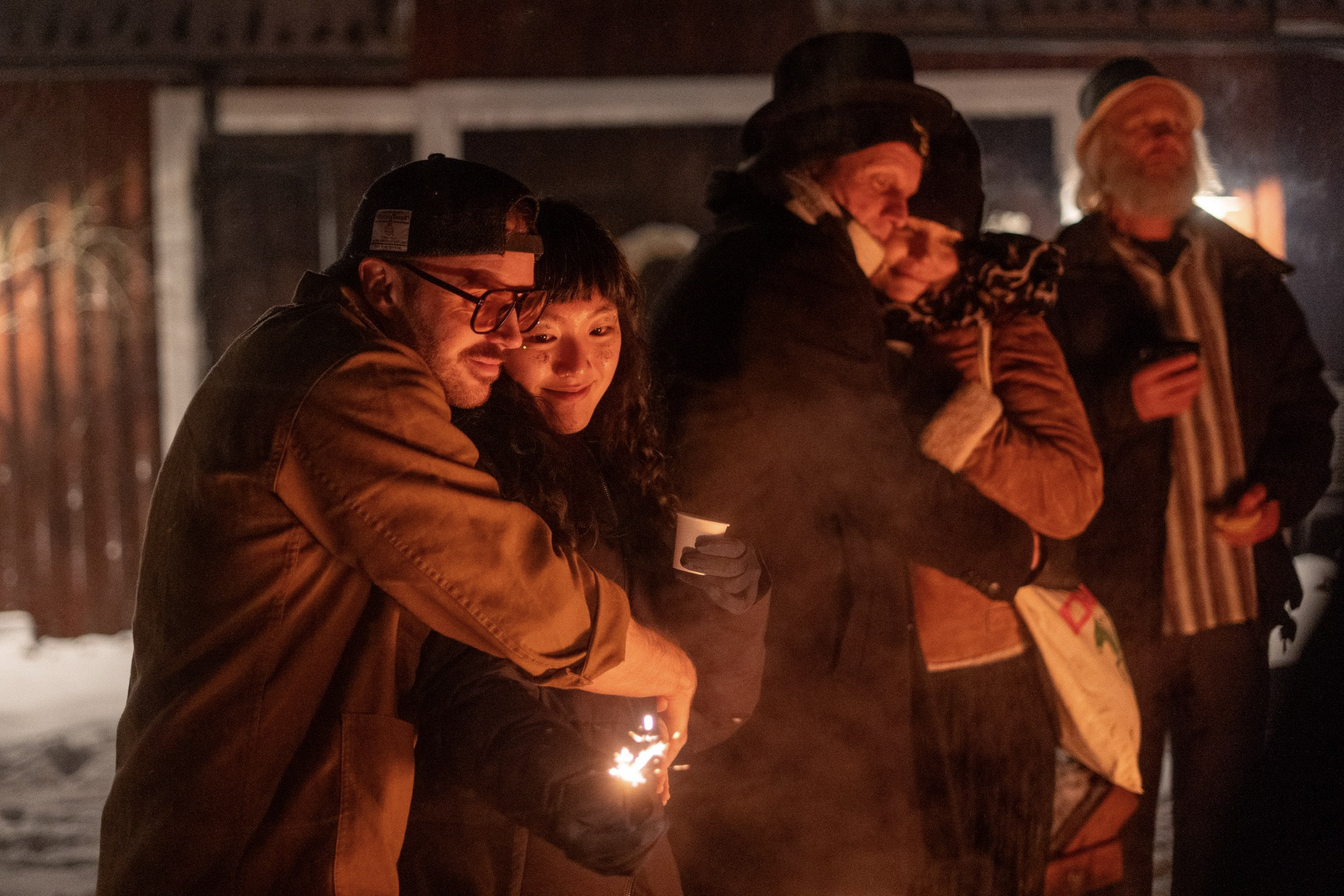 a group of people hugging in front of a fireplace